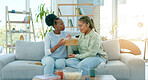 Black woman, friends and cry on sofa in support, care or understanding together at home. Sad African women with supportive friend crying on shoulder in living room couch for grief, emotion or loss