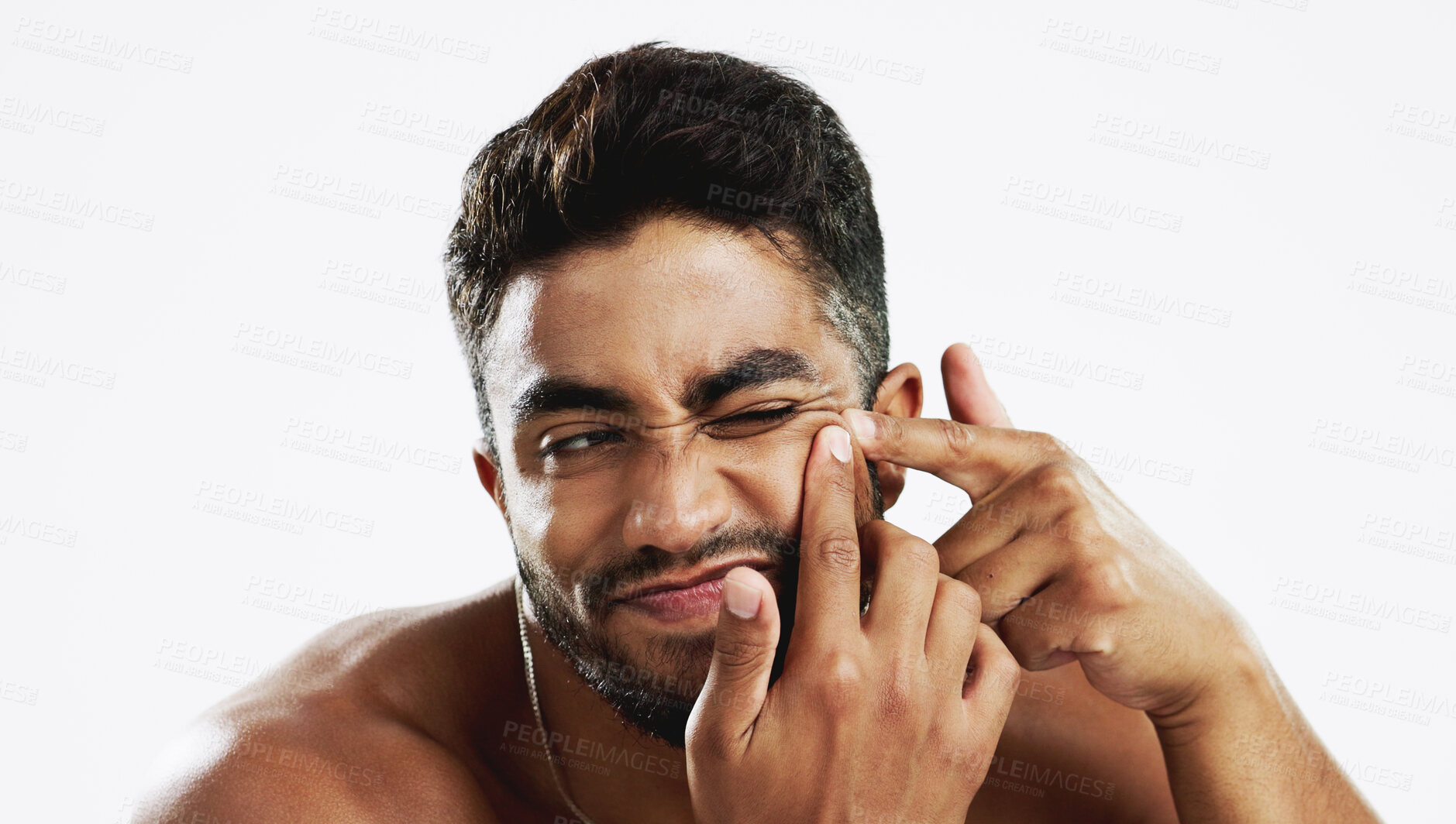 Buy stock photo Man, skincare and squeeze acne in studio for breakout, scratch spot and facial scar on white background. Face of indian model, beauty and press pimple for sensitive skin, blackhead and dermatology