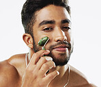 Face, beauty and man with facial roller, skincare and cosmetics against a grey studio background. Portrait, male ad guy with rose quartz, treatment and grooming with confidence, smooth and soft skin