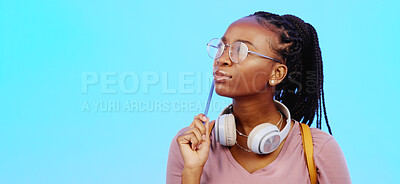 Black woman, thinking and gen z person with student vision and ideas in a studio copy space. Blue background, university students idea and headphones of a young female with glasses contemplating with pencil