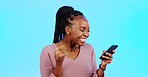 Black woman, smartphone and fist for celebration, lucky winner and achievement against a blue studio background. African American female, happy lady and cellphone with email, social media and victory