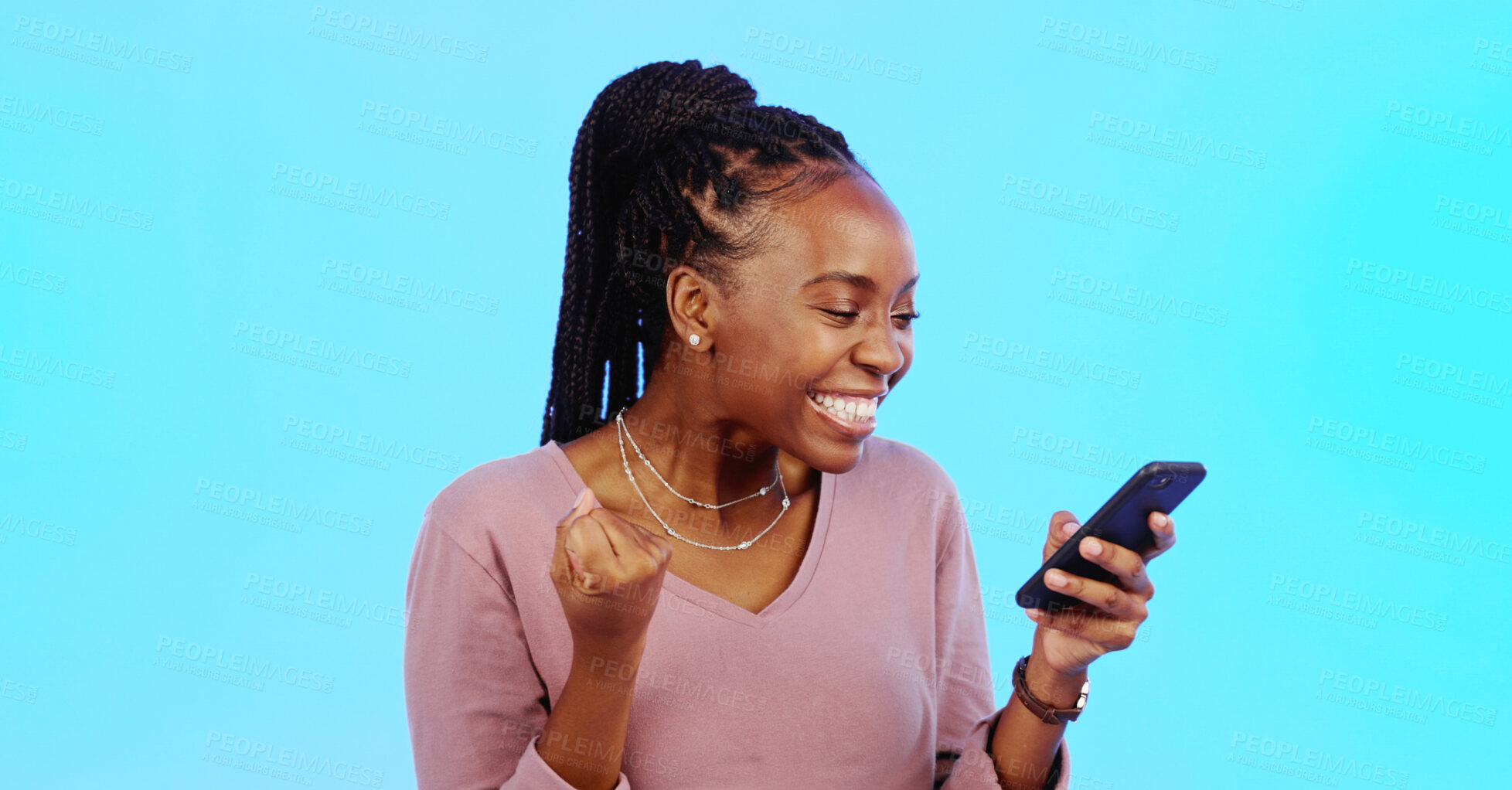 Buy stock photo Black woman, winner and phone for success, celebration and yes of news, competition or winning in studio. Excited person with yes, reading on mobile and achievement, sale or bonus on blue background