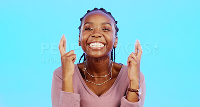 Face, fingers crossed and black woman with smile, hope and motivation with lady against blue studio background. Portrait, African American female and girl with gesture for luck, wish and emoji sign