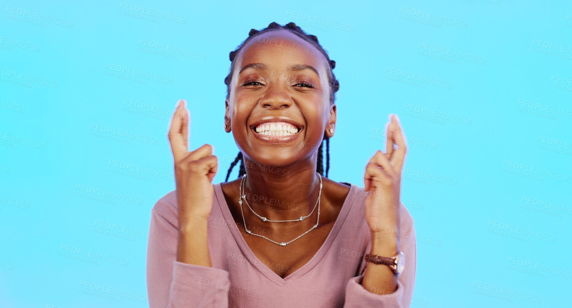 Buy stock photo Happy, woman and portrait with fingers crossed in studio for good luck, wish and giveaway winner on blue background. Face of african model hope for winning prize, optimism and smile with hand emoji