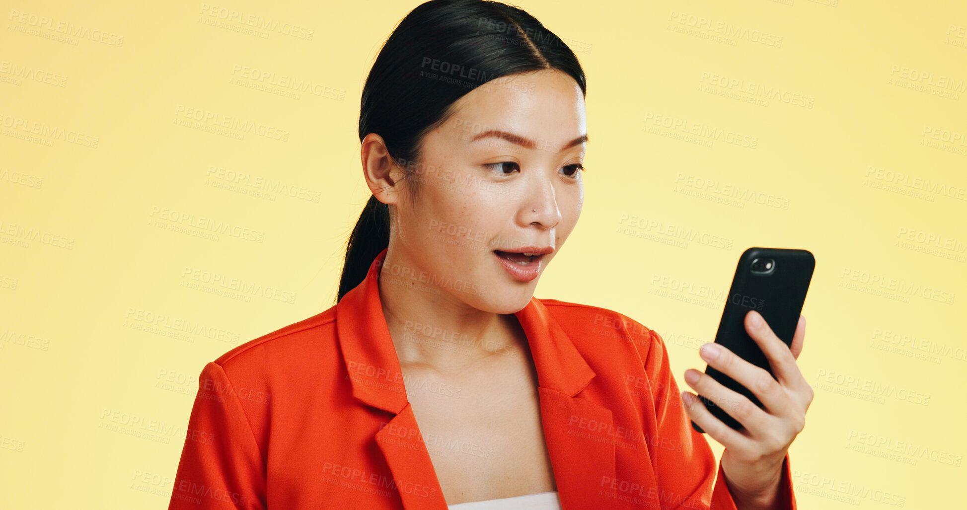 Buy stock photo Wow, news and woman with phone in studio for feedback, review or result on yellow background. Surprise, text and shocked Japanese female model with smartphone notification of app sign up winner 