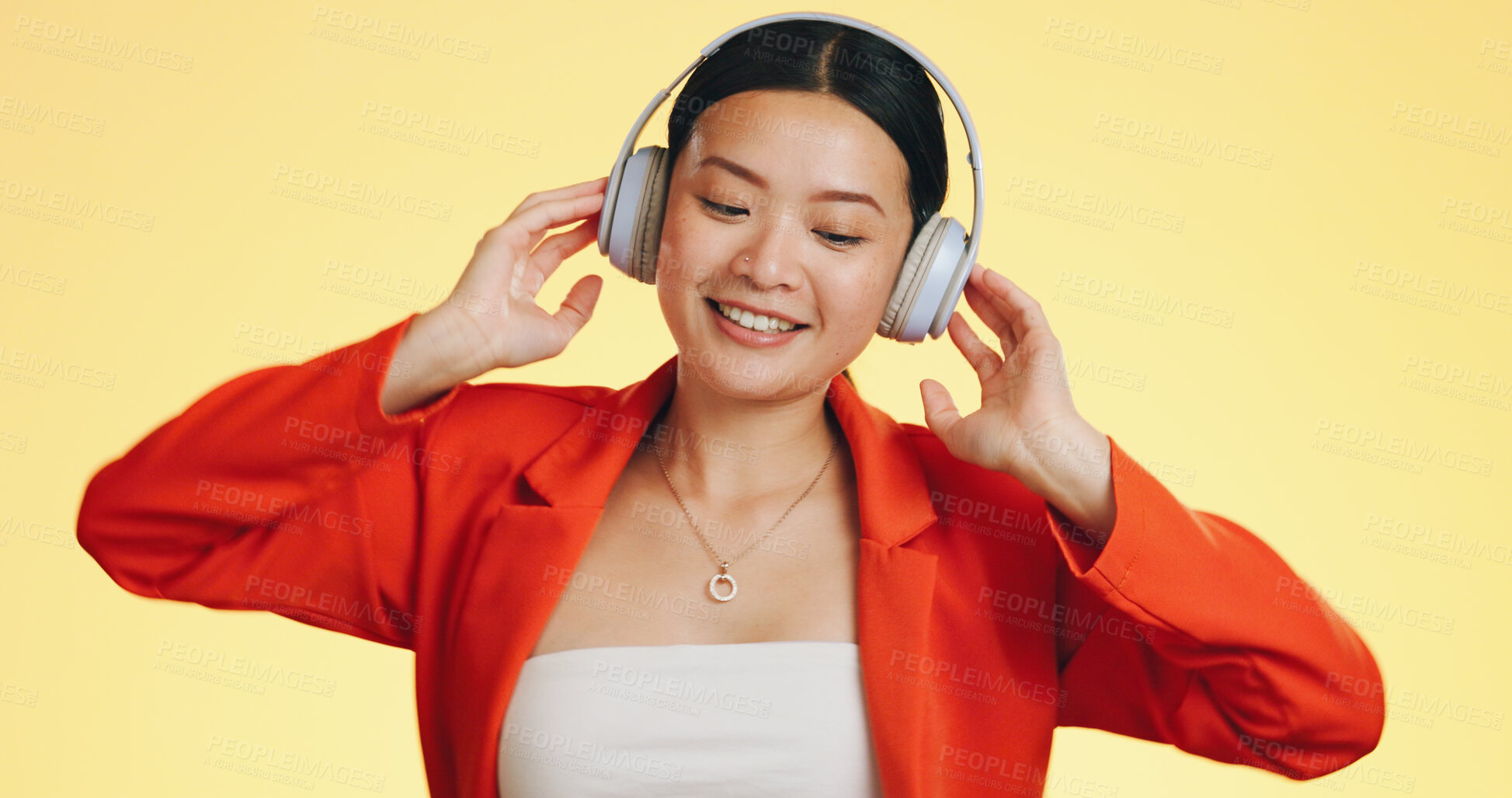 Buy stock photo Woman, headphones and listening to music with dancing, happy with wireless tech and audio streaming on yellow background. Fun, entertainment and radio with techno or rave, smile with energy in studio