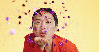 Studio, asian woman blowing confetti and celebration for birthday, anniversary or celebrating Chinese new year. Happy party, smile and model from china on yellow background to celebrate with glitter