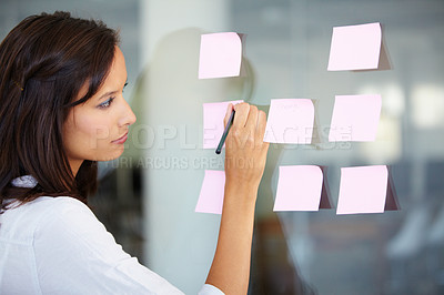 Buy stock photo Business woman, writing and planning for brainstorming, strategy or ideas on glass board at the office. Female employee working on tasks for reminder, sticky note or project plan at the workplace