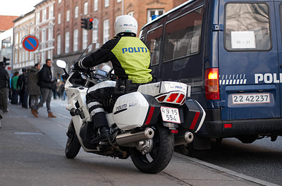 Buy stock photo Emergency, motorbike and city safety police officer working for protection and peace in an urban town in Denmark. Security, law and legal professional or policeman on a motorcycle ready for service