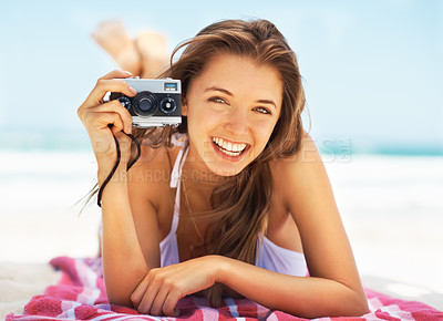 Buy stock photo Portrait, camera and a woman tourist on the beach during summer for a holiday or luxury vacation. Ocean, bikini and smile with a happy young female photographer on the sand to relax by a coastal sea