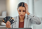 Finance, debt and credit with a business woman suffering from worry, stress and anxiety of inflation in the economy. Young female holding bank cards and having problems while trying to pay an account