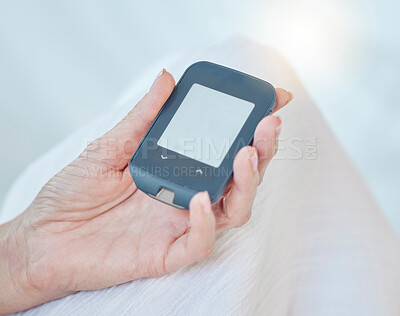 Buy stock photo Closeup of a senior diabetic woman checking her blood sugar glucose levels with a diabetes reading strips machine. One unknown elderly woman doing a blood sugar reading at home