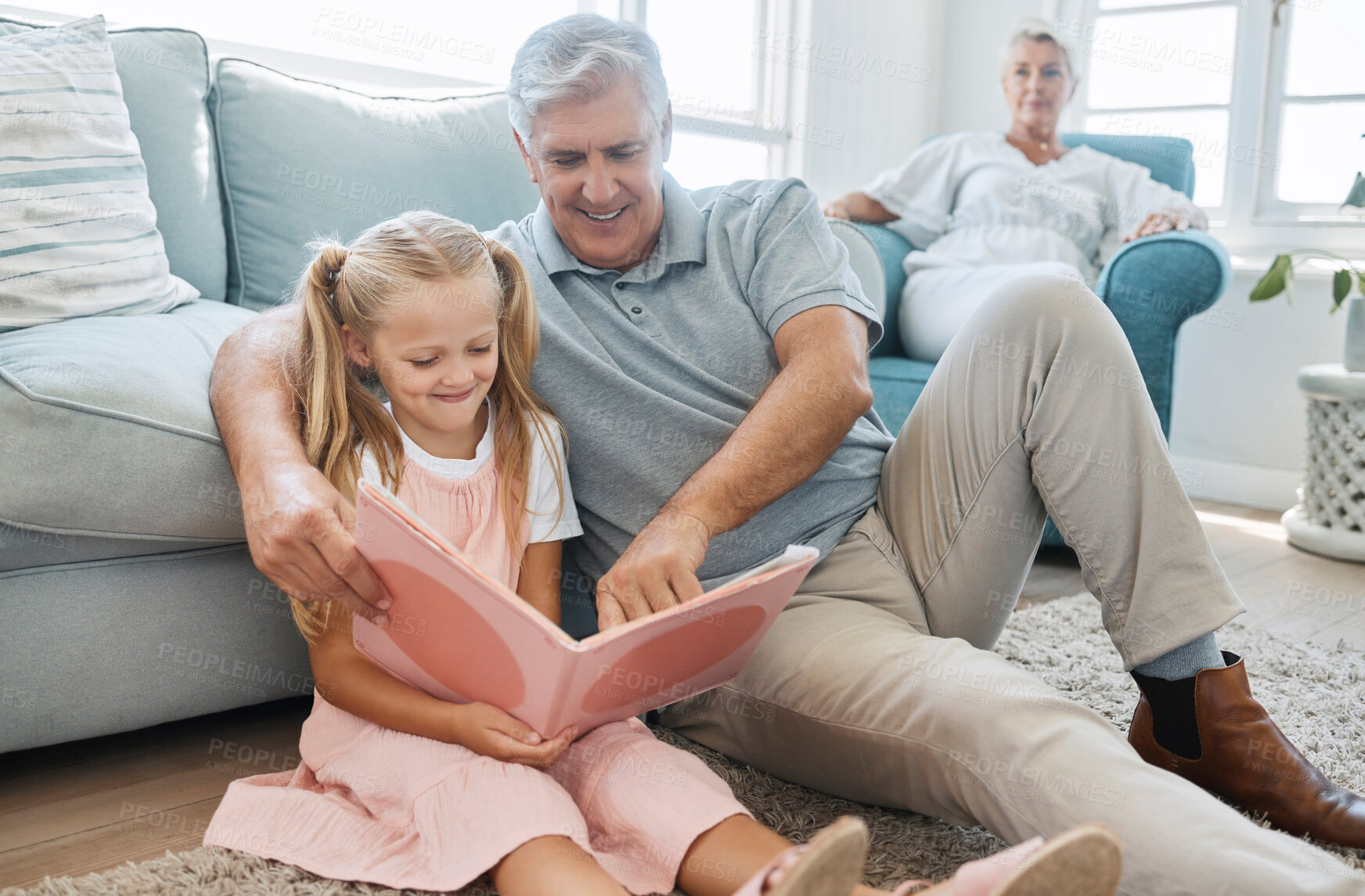 Buy stock photo Book, child and grandfather reading a story for education, knowledge and happiness together on the living room floor of their house. Elderly man helping a girl learn to read in the lounge of home