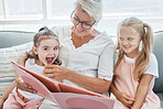 Grandmother, children and reading books on living room sofa in family home educational learning, funny and happy development. Grandma, girls and girl kids laughing, teaching story and relax on couch