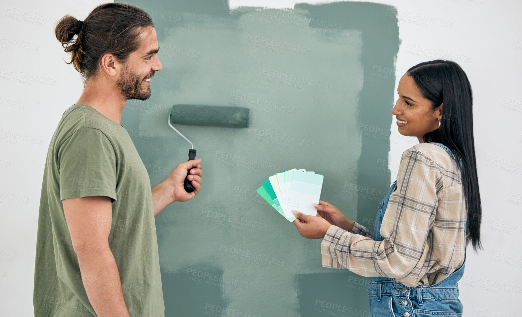 Buy stock photo Painting, wall and couple with color choice for home renovation, green room design and house project teamwork. Happy woman with partner with brush and green eco friendly paint decision or development