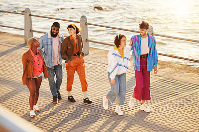 Buy stock photo Friends, sea and diversity with people walking on the promenade together during summer from above. Happy, smile and ocean with a man and woman friend group bonding during a walk outside by the beach