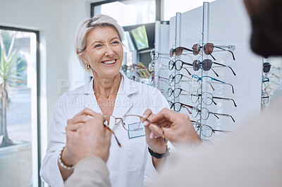 Buy stock photo Glasses, retail store and sale of a senior eye doctor holding a frame to help customer shopping. Happy optometrist, shop wellness and service of an elderly eyes expert with eyeglasses vision check