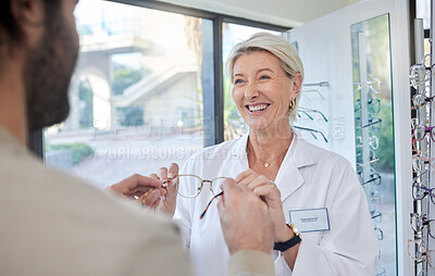 Buy stock photo Glasses, retail shop and vision of a senior eye doctor holding a frame to help customer shopping. Happy optometrist, store help and service of an elderly eyes expert with eyeglasses check promo