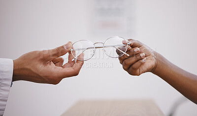 Buy stock photo Hands, vision or glasses with an optometrist and customer in an eyewear store closeup for prescription lenses. Healthcare, medical and optometry with a optician giving frame spectacles to a client