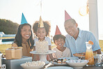 Birthday cake, children and family portrait in summer for group celebration, party and parents, love and care. Happy interracial people, kids or girl celebrate on outdoor patio, dessert and holiday