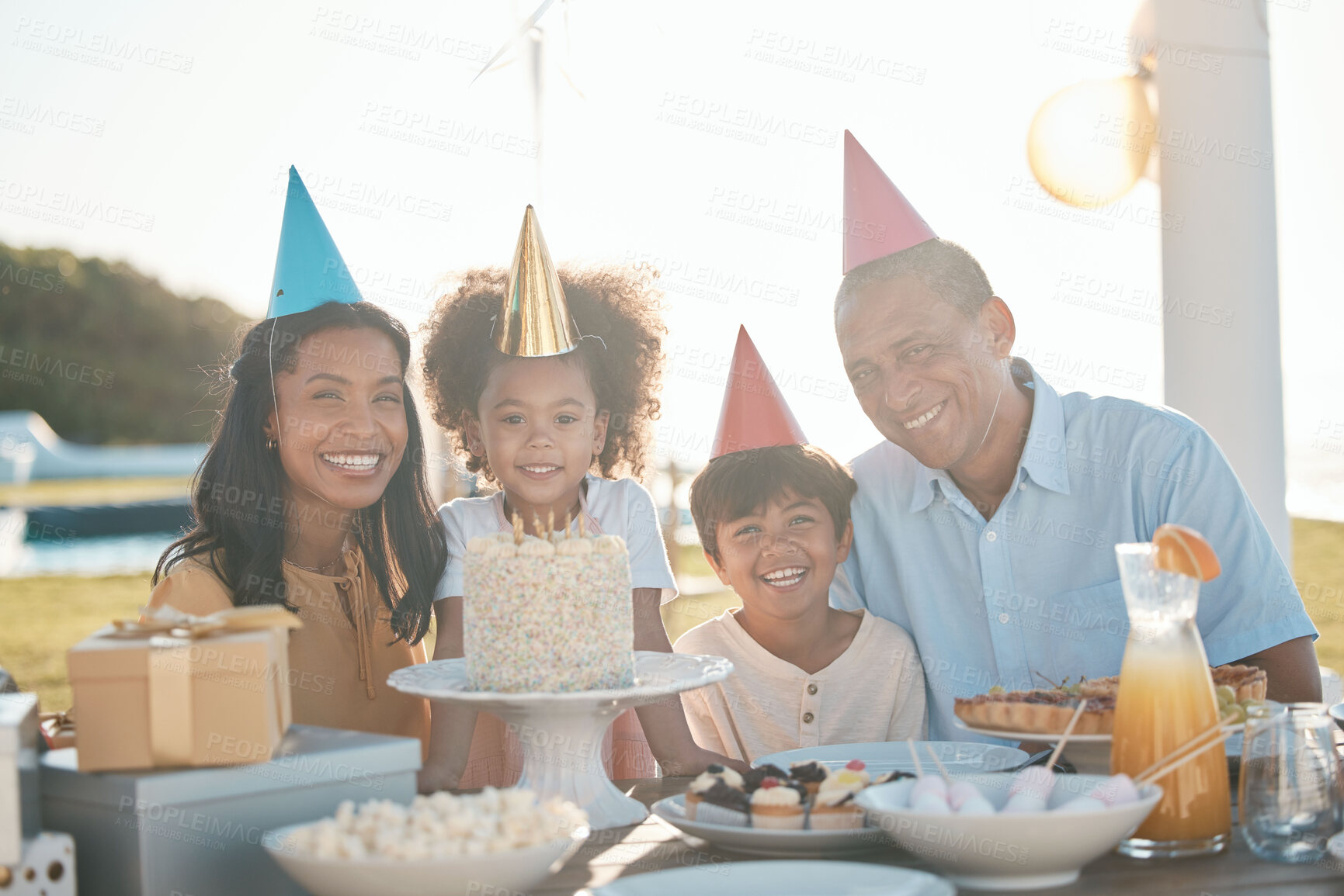 Buy stock photo Birthday cake, children and family portrait in summer for happy celebration, party and parents, love and care. Interracial people, kids or girl celebrate on outdoor patio, dessert and holiday food