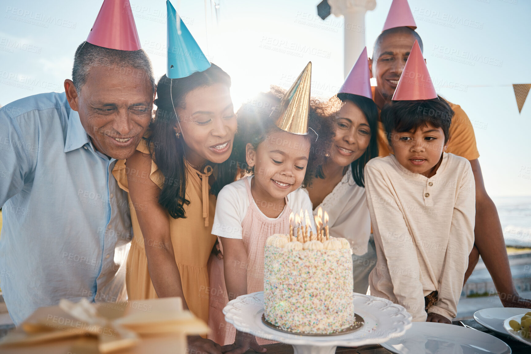 Buy stock photo Birthday cake, children and senior family in summer for group celebration, party and grandparents love and care. Happy latino people with kids or girl celebrate on outdoor patio, holiday and candles