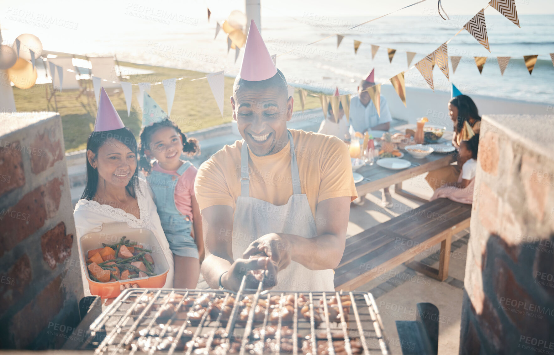 Buy stock photo Help, birthday and family at barbecue party, lunch and summer in nature together. Camping, smile and woman helping a man with food on the grill, cooking bbq and meat on vacation by the sea for dinner