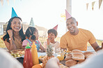 Happy parents and children at birthday in park for event, celebration and party outdoors together. Family, social gathering and mother, father with kids at picnic with cake, presents and eating food