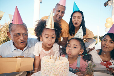Buy stock photo Family, birthday and girl is blowing candles with party hats for celebration at house for fun. Happiness, kid and make a wish with cake or children, grandparents for special event in outdoor.