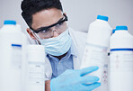 Container check, chemical bottle and man at scientist job with mask at pharmaceutical lab. Research, label reading and science of a male worker with manufacturing work and chemistry inventory 