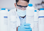 Stock check, chemical bottle and man scientist with mask at pharmaceutical lab working. Research, container label reading and science of a male worker with manufacturing job and chemistry inventory 