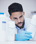 Laboratory, man or scientist reading bottle at pharmaceutical laboratory checking stock or info on cure. Research, container label or science researcher in manufacturing job with chemical inventory