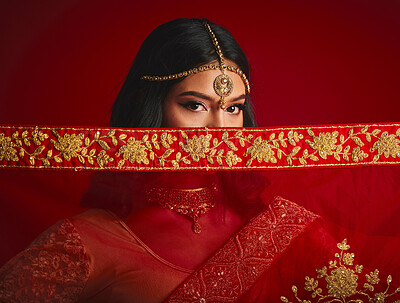 Buy stock photo Fashion, eyes and portrait of Indian woman with veil in traditional clothes, jewellery and sari. Religion, beauty and female person on red background with accessory, cosmetics and makeup for culture