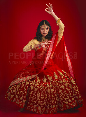 Buy stock photo Portrait, dance and Indian woman with fashion, traditional dress and celebration against a red studio background. Face, female person or model with cultural clothes, jewellery and dancing with beauty