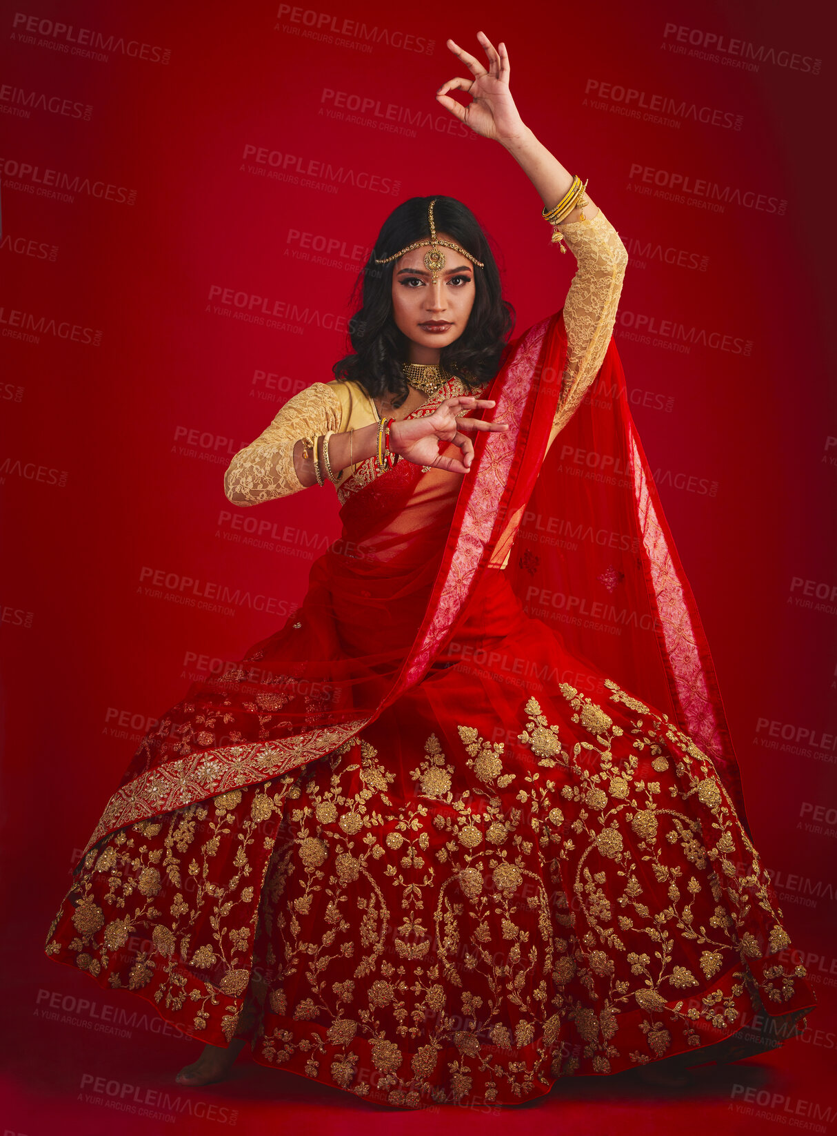 Buy stock photo Portrait, dance and Indian woman with fashion, traditional dress and celebration against a red studio background. Face, female person or model with cultural clothes, jewellery and dancing with beauty