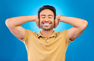Buy stock photo Sound, silence and man cover ears, noise and happiness against a blue studio background. Male person, guy and model silent, gesture and quiet with a smile, happy and relax with peace, calm and joyful