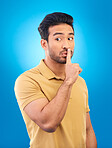 Asian man, secret and finger on lips in studio for privacy, mystery and sale announcement on blue background. Male model, silence and shush for quiet, gossip or whisper emoji of confidential surprise