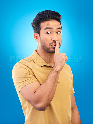 Buy stock photo Asian man, secret and finger on lips in studio for privacy, mystery and sale announcement on blue background. Male model, silence and shush for quiet, gossip or whisper emoji of confidential surprise