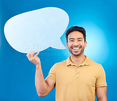 Buy stock photo Man, speech bubble and studio portrait with smile for opinion, social media and poster by blue background. Indian guy, student or model with billboard, mockup space and cardboard sign for promotion