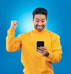 Winner, surprise and excited Asian man with phone in studio for online bonus, competition and prize. Success, smartphone and happy male person on blue background for promotion, winning and good news