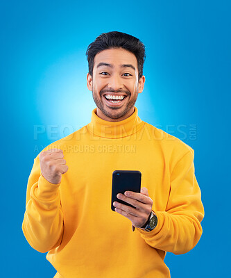 Buy stock photo Winner, excited and portrait of Asian man with phone in studio for online bonus, competition and prize. Success, smartphone and male person celebrate on blue background for promotion, winning or news