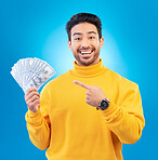 Money, studio portrait and happy man point at dollar bills, competition reward or bonus salary prize. Savings pay, cash winner and excited person show income, success or wealth on blue background