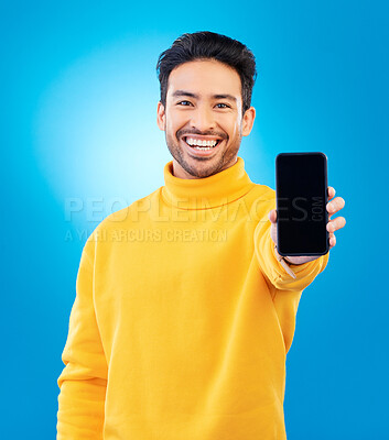Buy stock photo Marketing, portrait of man with smartphone and blue background happy for online communication. Tech app or social networking, advertising or branding and male person with cellphone screen in studio
