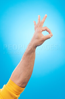 Buy stock photo Hand, ok sign and studio closeup for agreement, vote and choice with emoji by blue background. Finger icon, communication and promotion with symbol, review and decision with opinion by backdrop