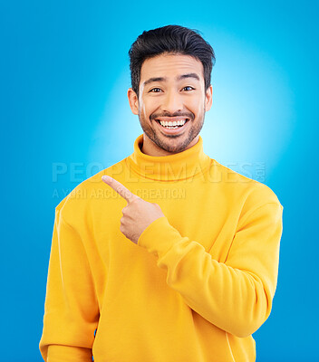 Buy stock photo Man, point and smile in studio portrait with choice, fashion and promotion with excited face by blue background. Young Indian guy, gen z student and finger for decision, icon and opinion with clothes