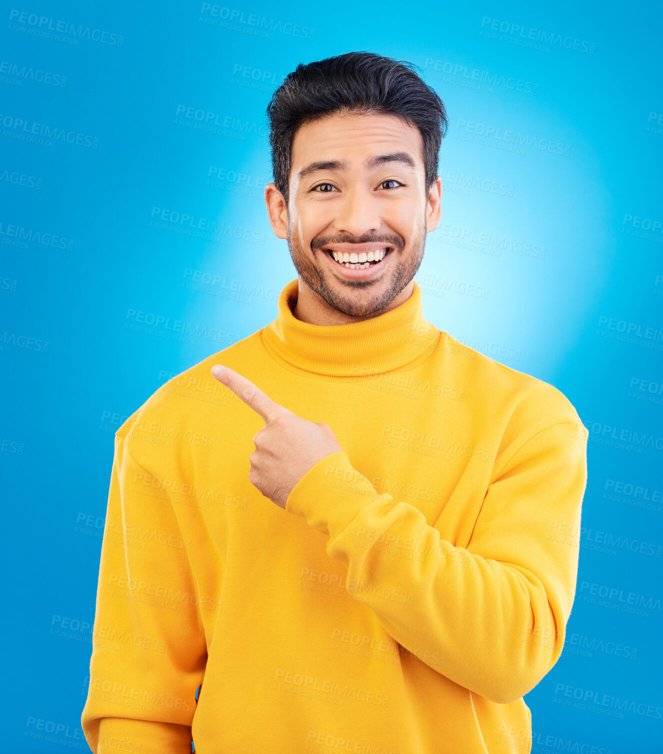 Buy stock photo Man, point and smile in studio portrait with choice, fashion and promotion with excited face by blue background. Young Indian guy, gen z student and finger for decision, icon and opinion with clothes