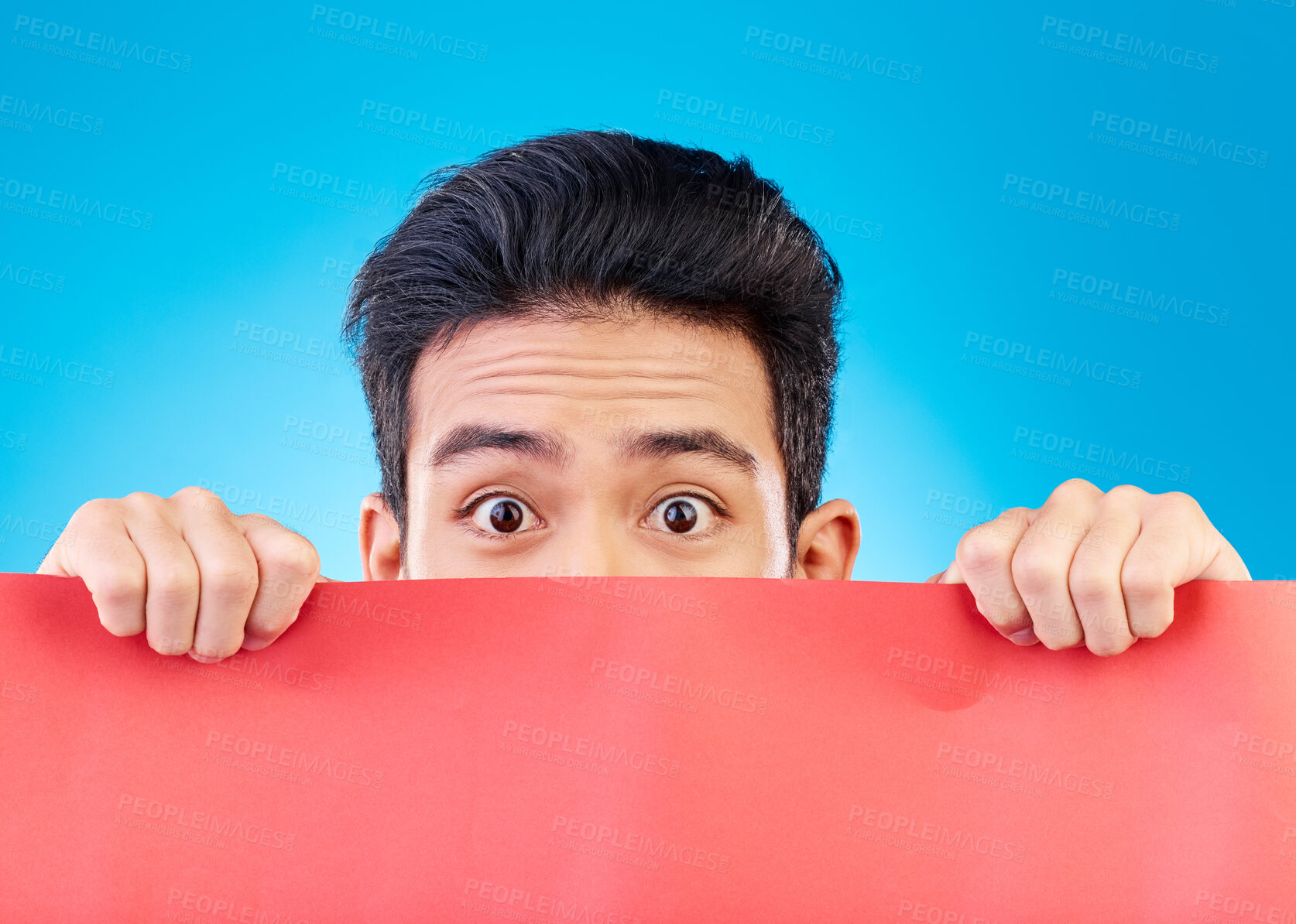 Buy stock photo Portrait, poster and mockup with a man hiding in studio isolated on a blue background for advertising information. Eyes, sign and a male brand ambassador showing empty space for a marketing logo