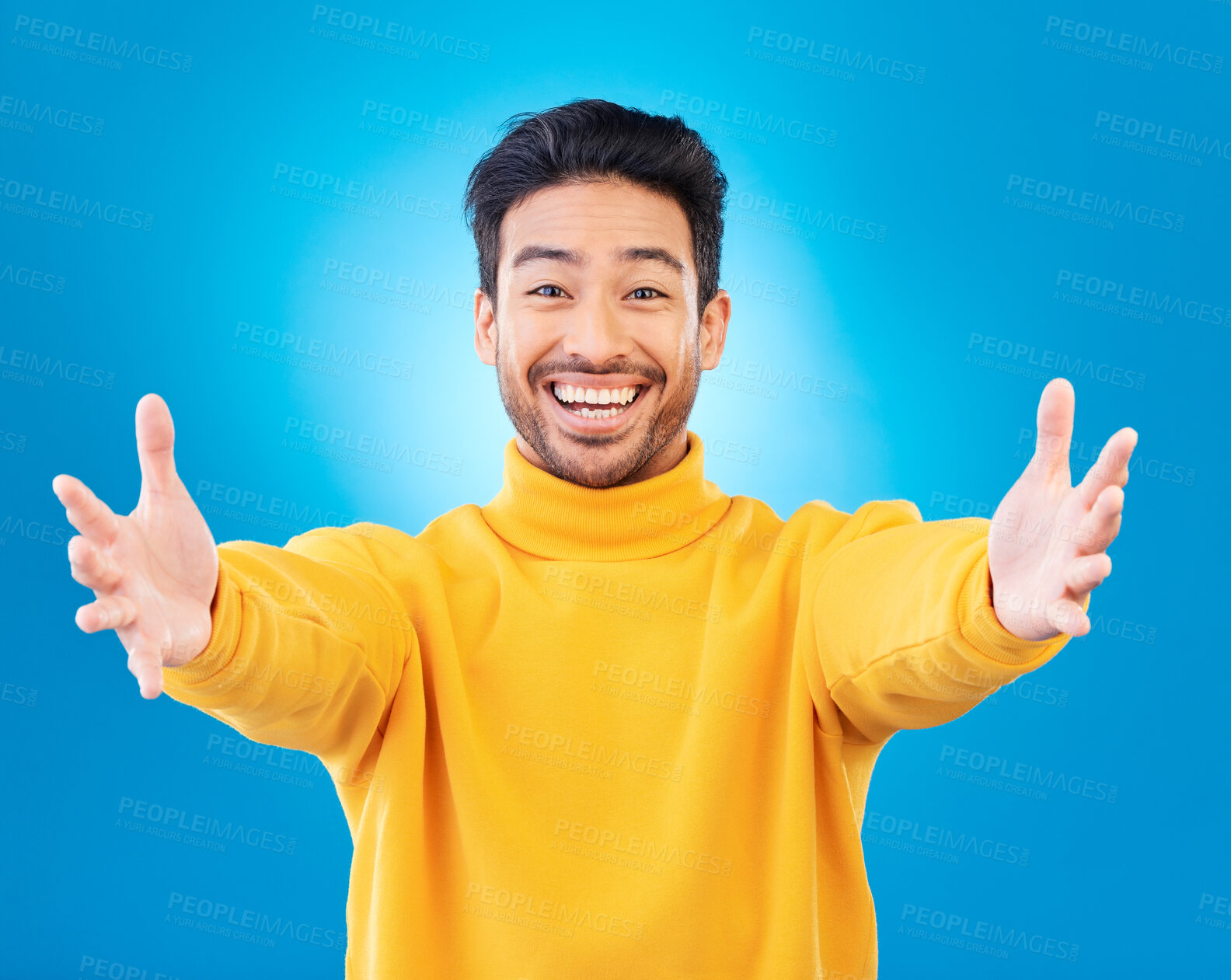 Buy stock photo Portrait, welcome and arms outstretched with a man on a blue background in studio for a friendly hug. Smile, trust and hello with a happy young male person reaching indoor to offer a greeting
