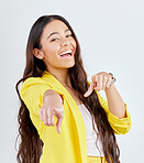 Portrait, pointing and decision with an excited woman in studio on a gray background to select you. Smile, hands and choice with a happy young female model in yellow clothes to vote on an option