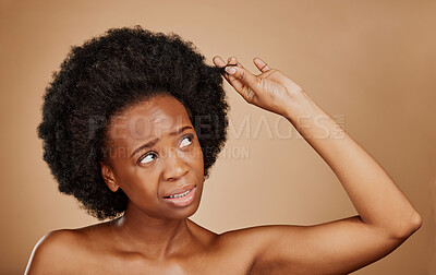 Buy stock photo Worry, black woman and hair loss problem for afro in studio isolated on a brown background. Crisis, hairstyle and frustrated African model with split ends, frizz and damage in natural salon treatment